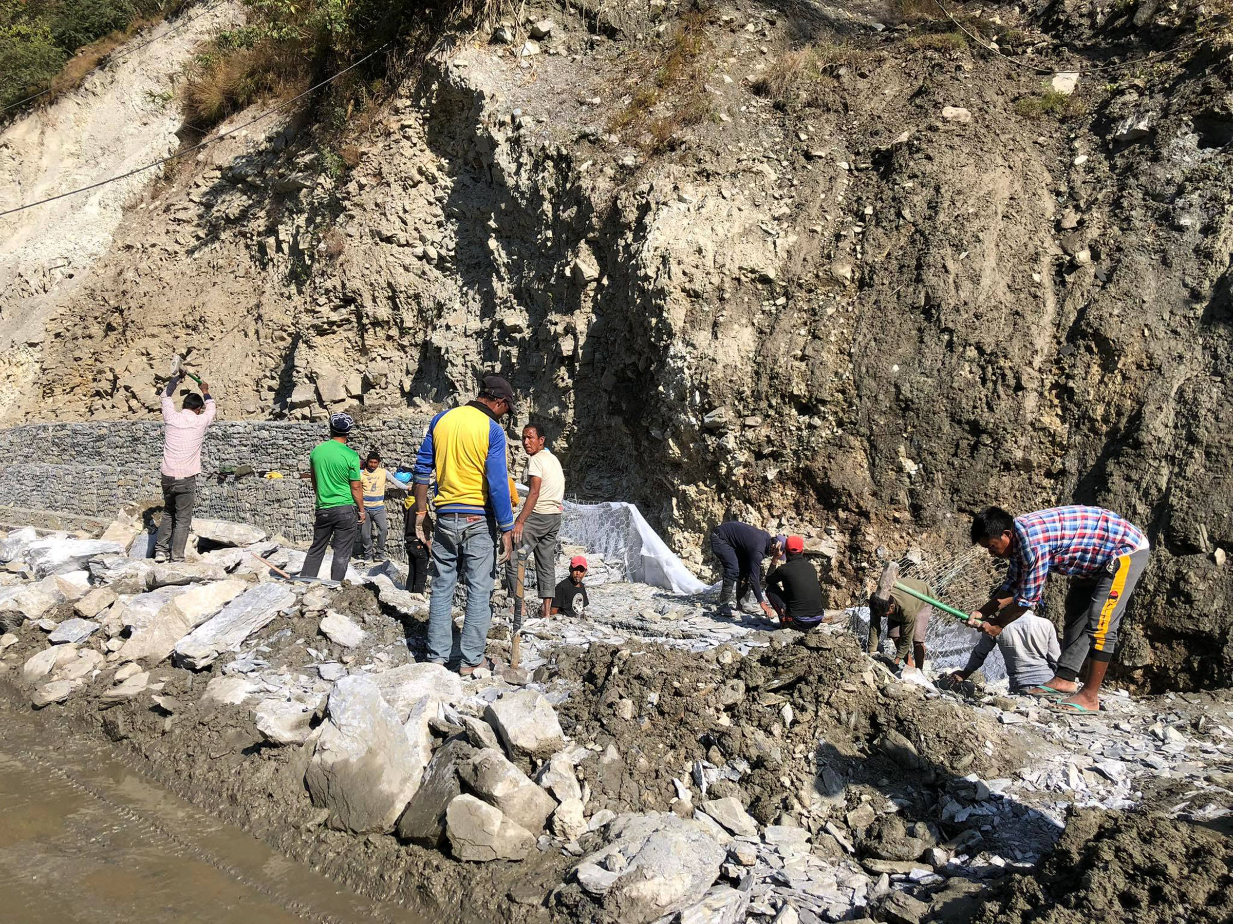 सडक स्तरोन्नतिको लागि काम गर्दै मजदुर