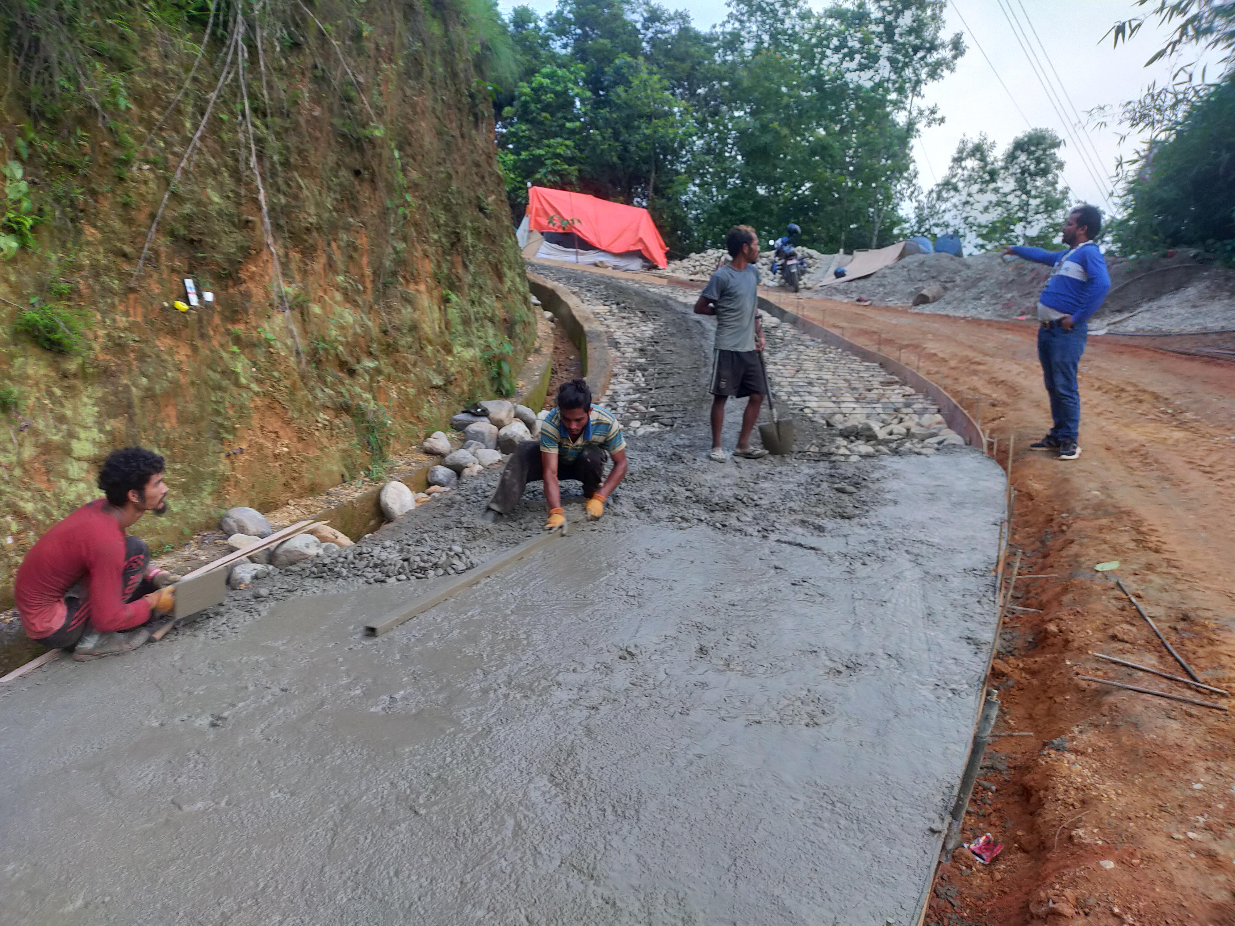 ग्रामीण सडक ढलान गर्दै मजदुर