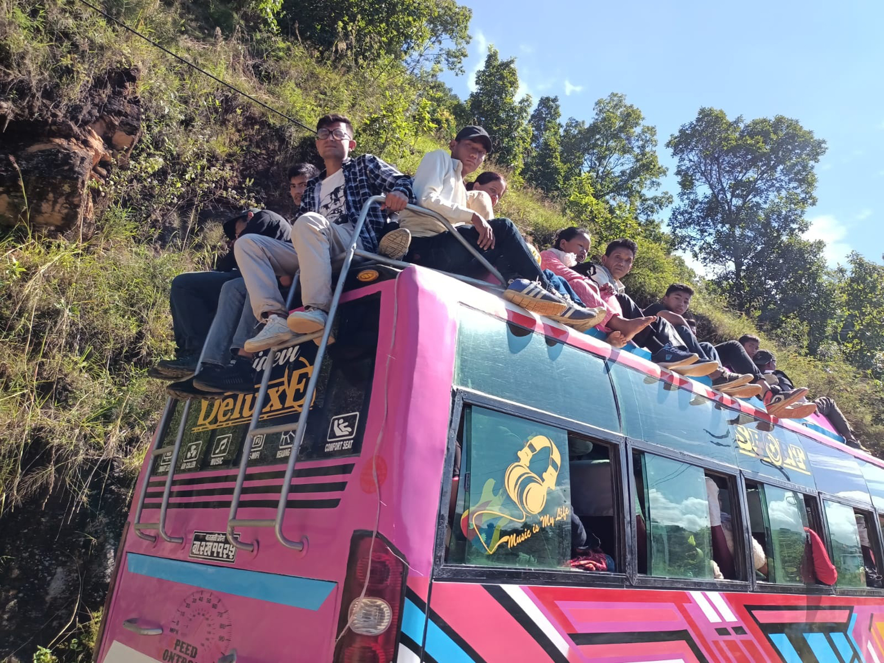 बसको छतमा यात्रा गर्दै यात्रु