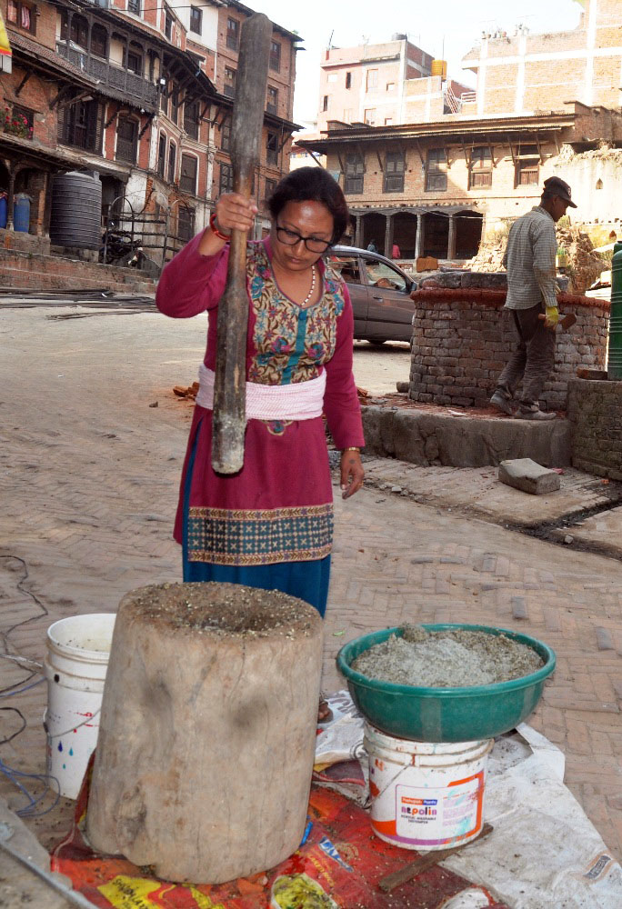 ओखलमा मासको दाल कुट्दै
