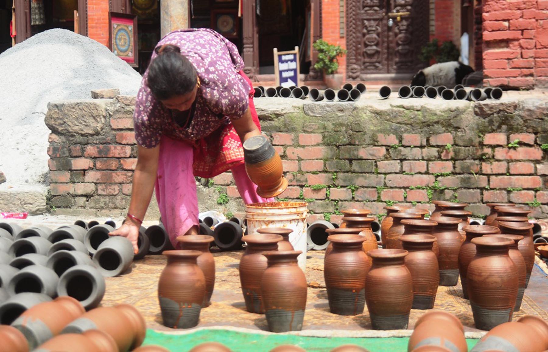 गपचामा रातो माटाको रङ्ग लगाउँदै व्यवासायी