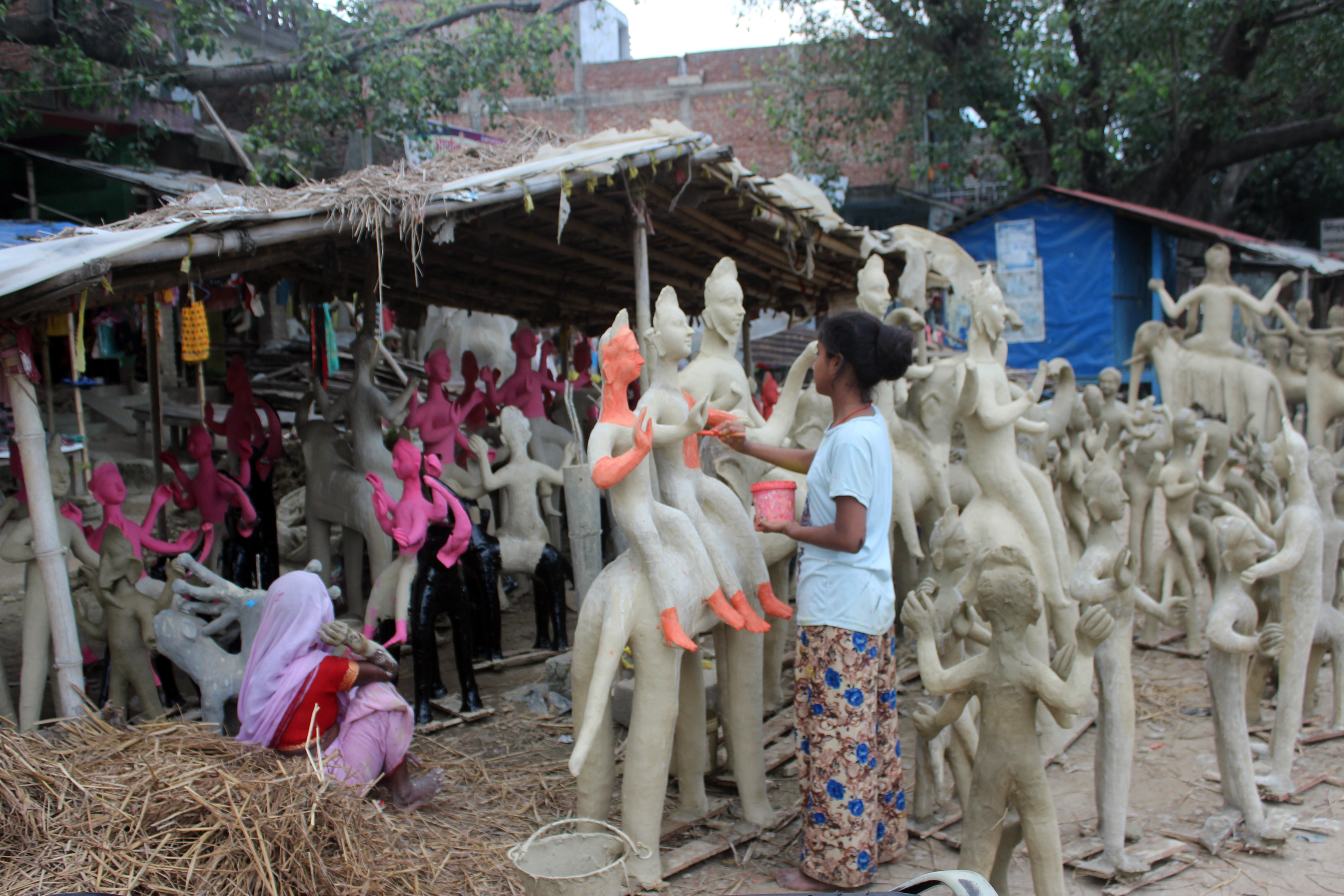 मूर्तिमा रङ्ग लगाउँदै मूर्तिकार