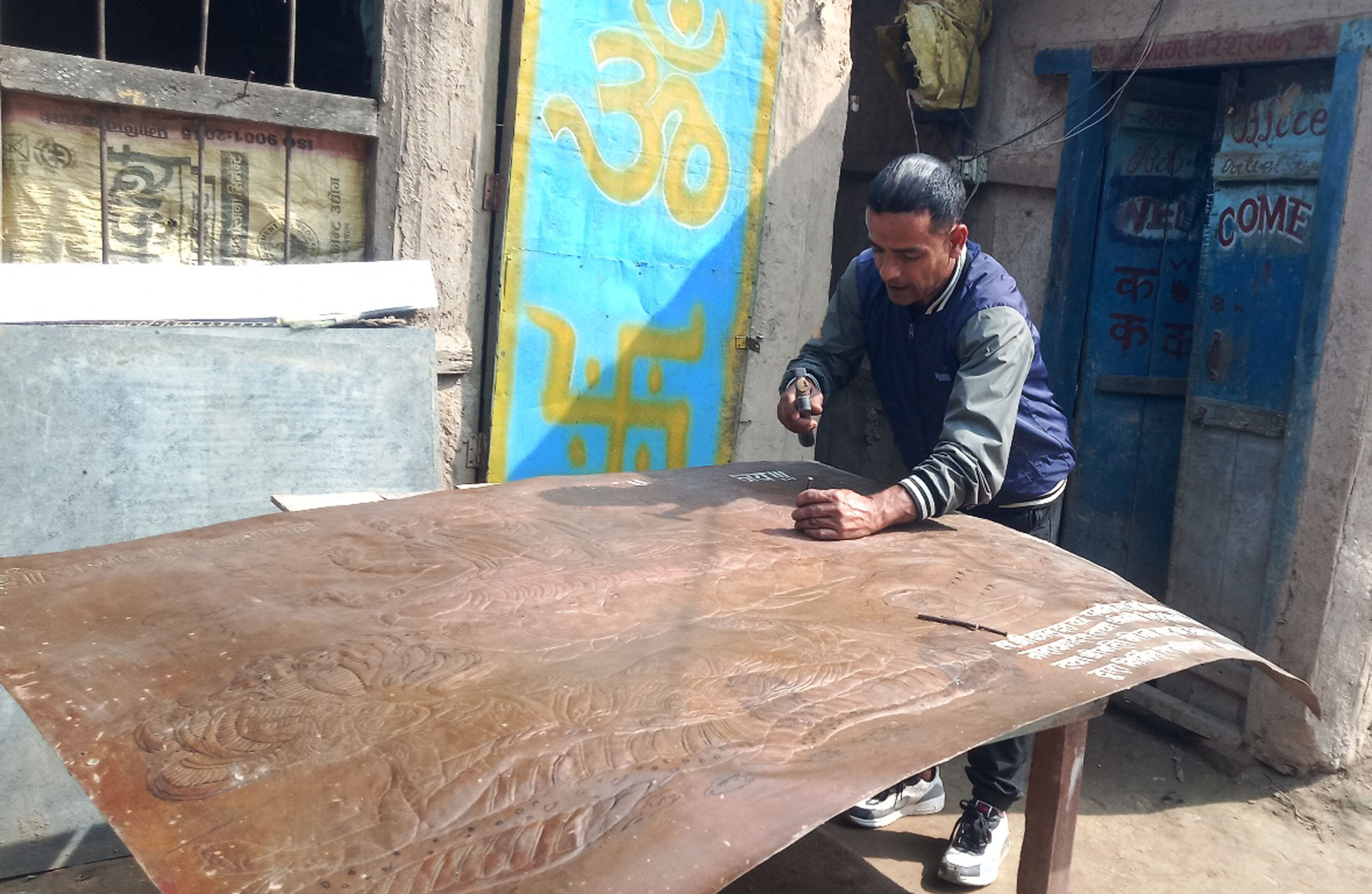 धातुमा खोपेर चित्र बनाउँदै