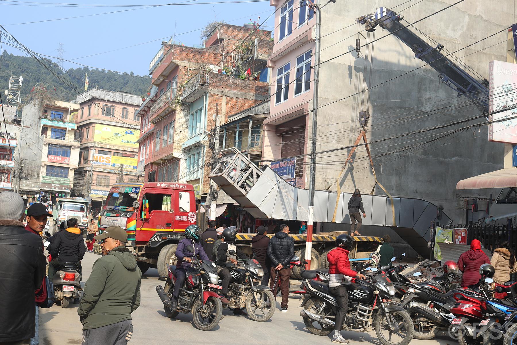क्रेनको सहायताले सामान सार्ने काम गरिंदै