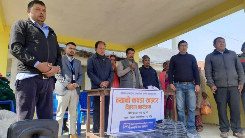 विद्यार्थीलाई जाडोको न्यानो कपडा हस्तान्तरण गर्दै : माछापुच्छ्रे बैंक