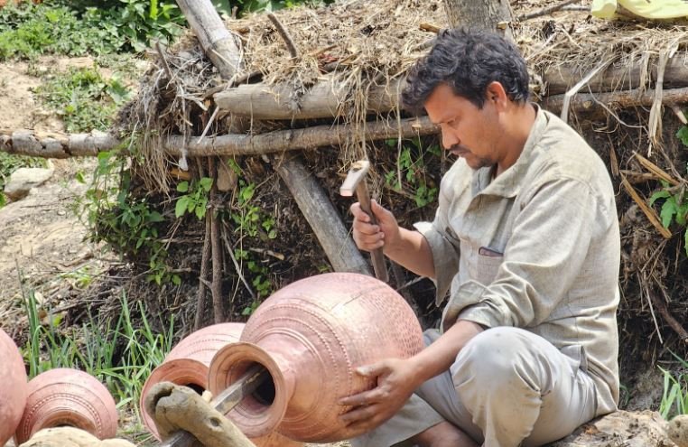 तामाको भाँडा बनाउँदै