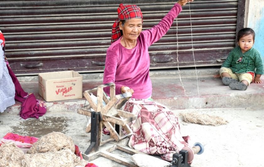 चर्खामा अल्लोको धागो कात्दै- महिला