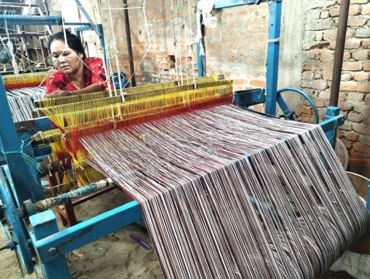 कपडा बुन्दै महिला