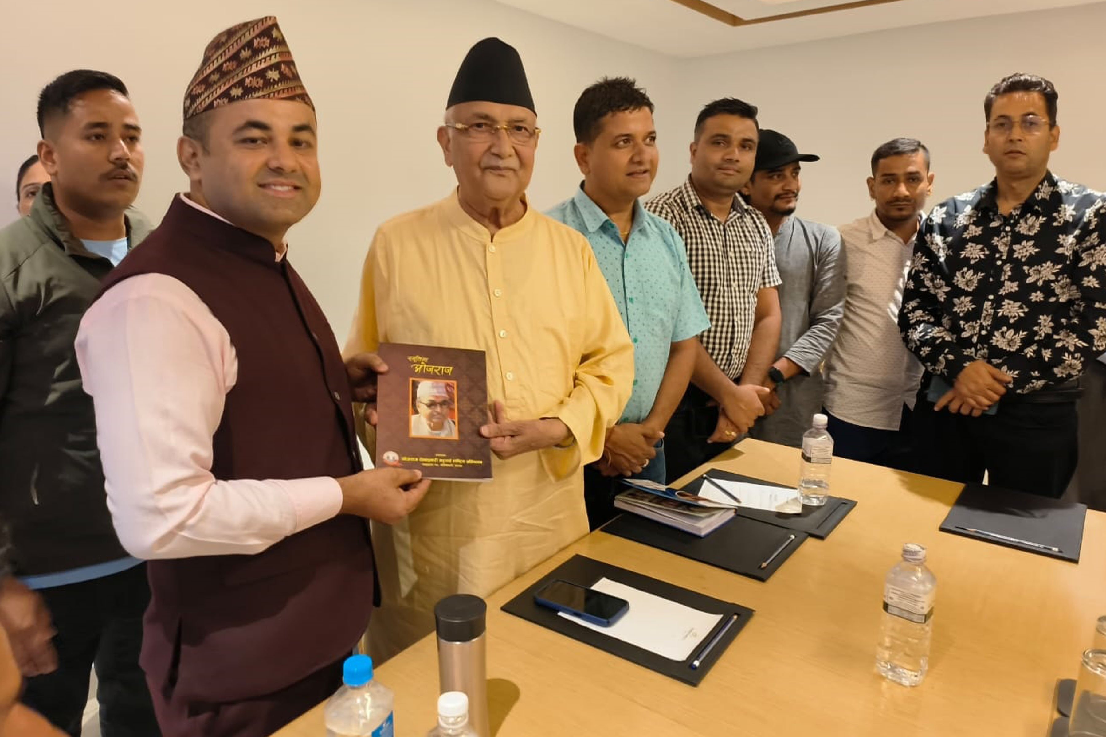 पुस्तक ग्रहण गर्नुहुँदै अध्यक्ष ओली