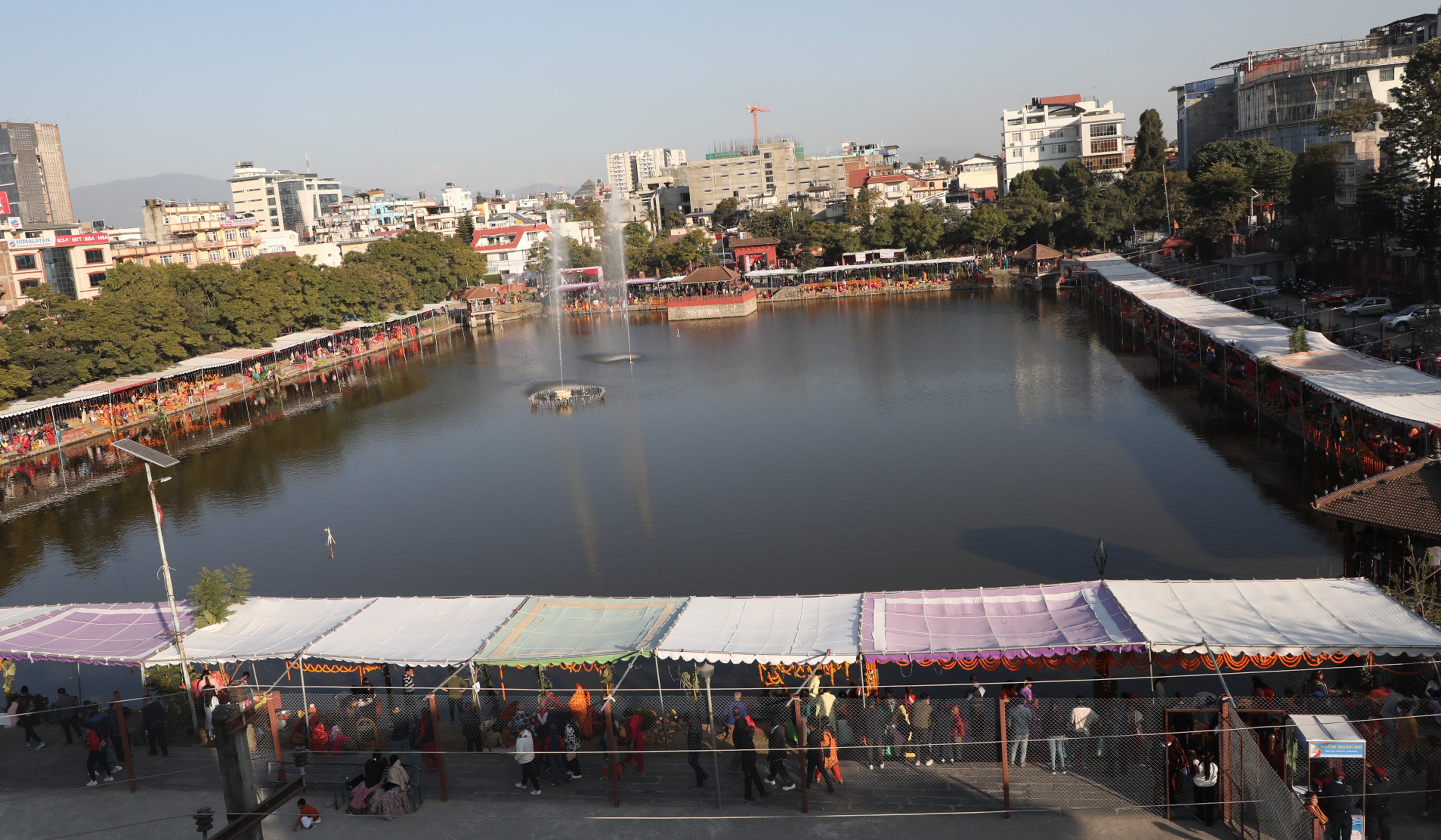 कमलपोखरीमा अस्ताउँदो सूर्यलाई पूजा गर्न बसेका भक्तजन